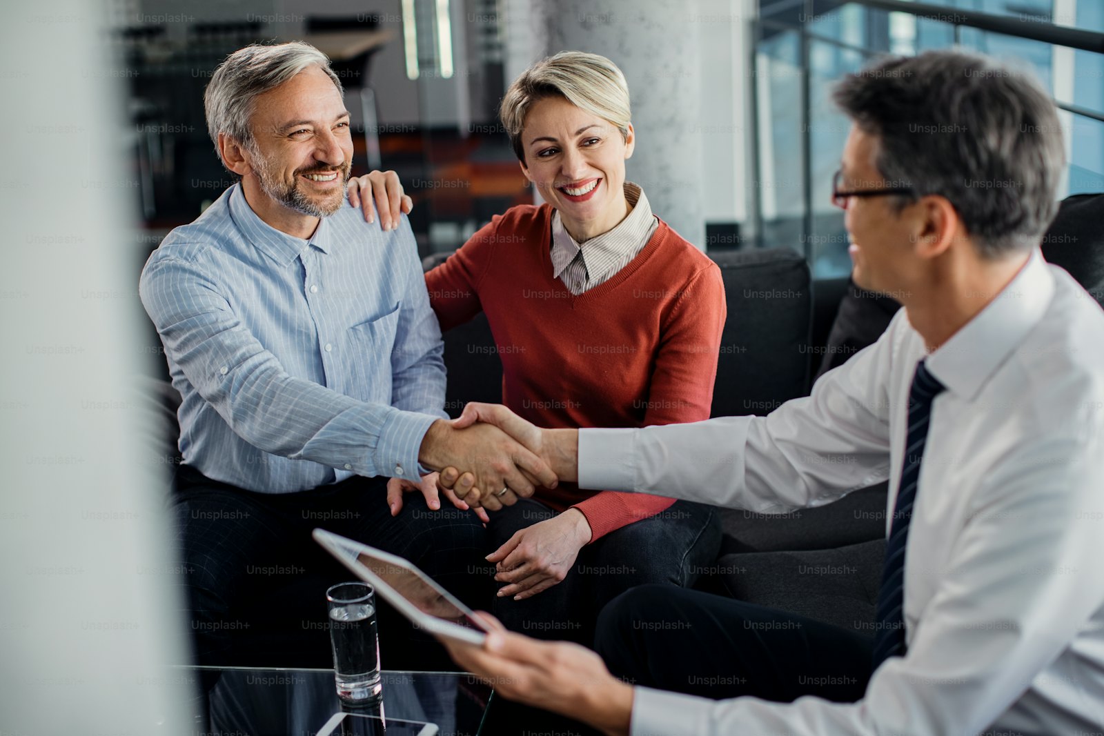 Professional shaking hands with a client across an office desk