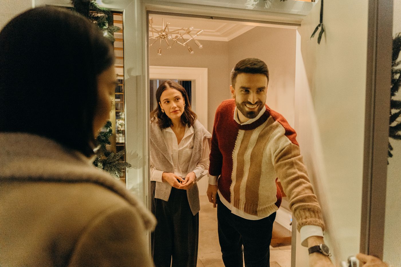 Friendly person opening a door to welcome a visitor into an office