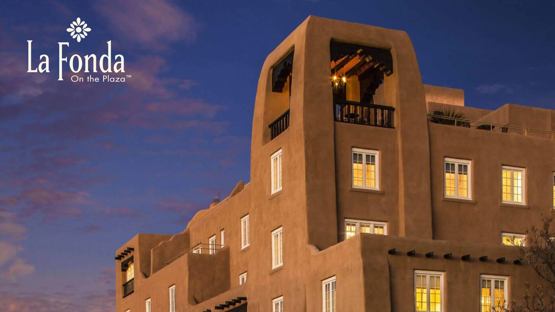 Historic adobe buildings on the Santa Fe Plaza at dusk, near the La Fonda hotel